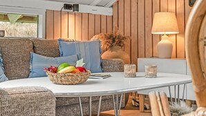 A cozy seating area with a white table, wicker basket with fruits, and a lamp. - "Wilmer" - 600m from the sea by Interhome (Løkken)