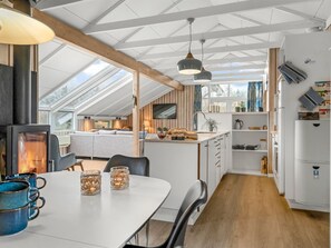A modern kitchen with a central island, wooden beams, and a skylight. - "Wilmer" - 600m from the sea by Interhome (Løkken)