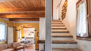 A rustic interior with a wooden ceiling, a stone staircase, and a cozy seating area with patterned cushions. - Wonderful private villa for 6 guests with WIFI, TV, patio and pets allowed (Rialto)