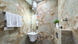 A bathroom with a marble wall, a sink, a toilet, and a towel rack. - Guru Sadan | A Luxe Stay (Faizabad)