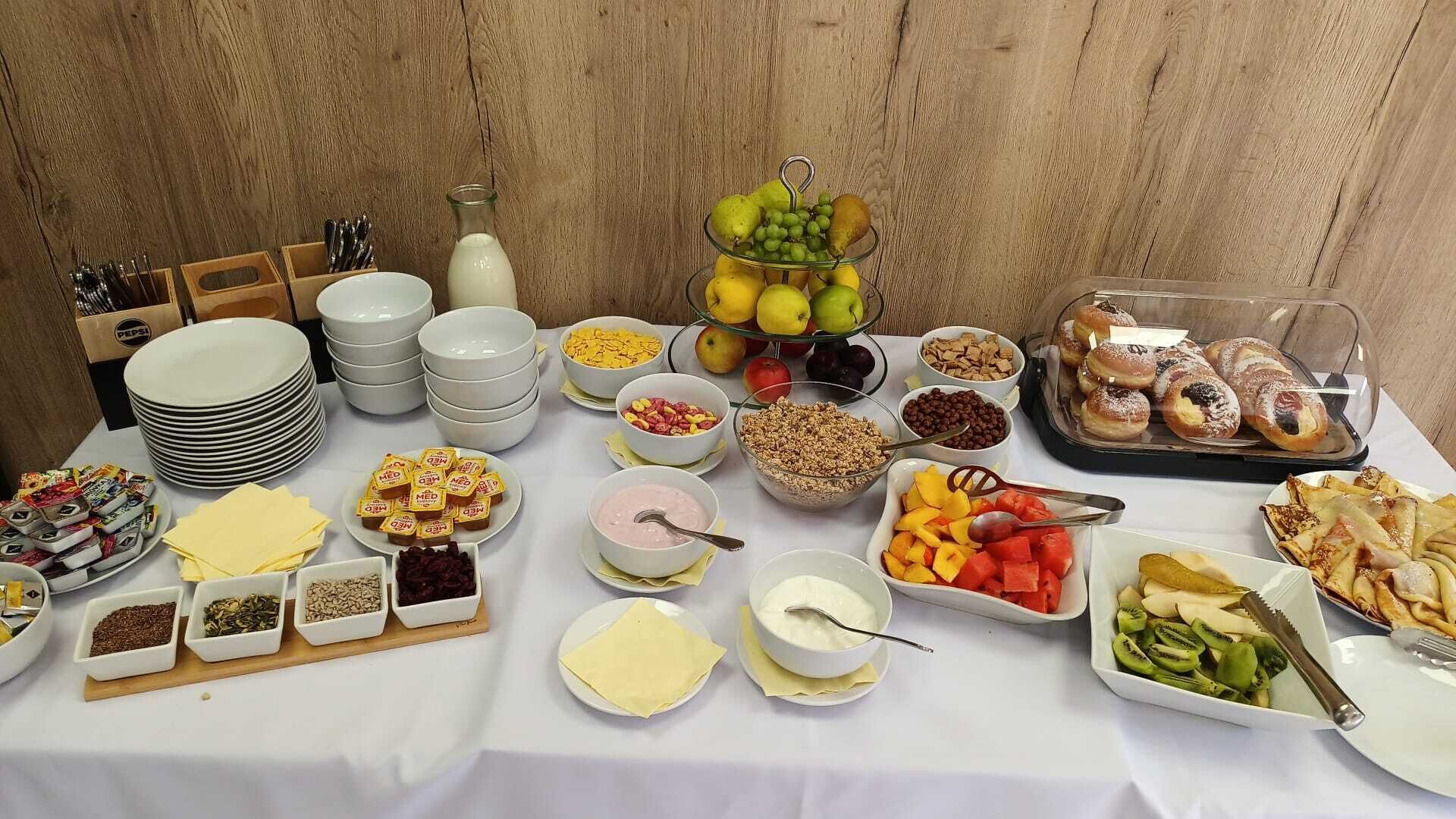 A buffet table with various food items and condiments.