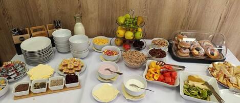 Una mesa de buffet con diversos alimentos y salsas.