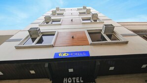 Un hôtel avec une enseigne indiquant « fabHOTELS » et « HOTEL ROSEWOOD INN », ce qui permet d’identifier le nom et le type d’établissement.