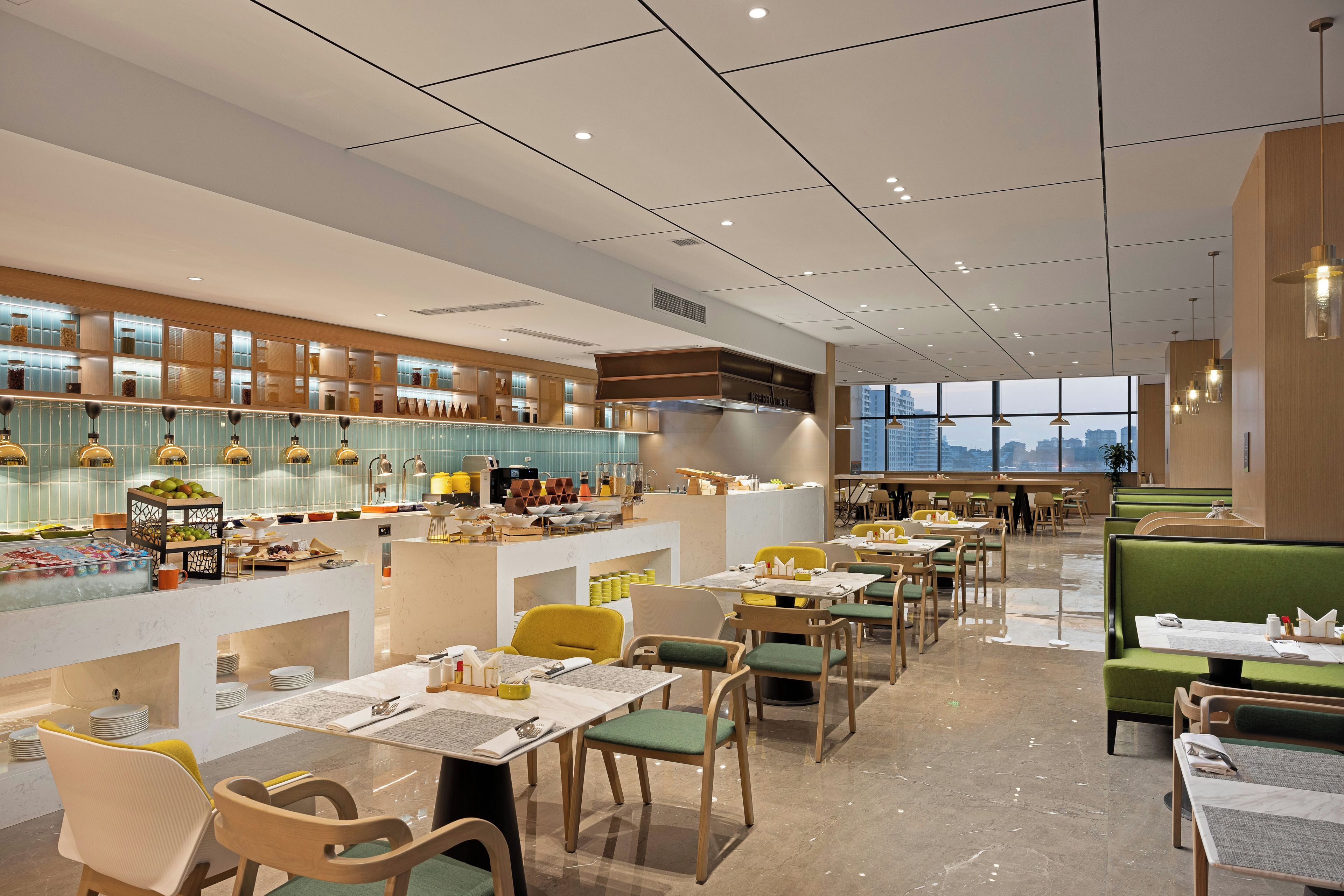 Un interior de restaurante moderno con techos altos, una barra de servicio central y zonas de estar con mesas y sillas.
