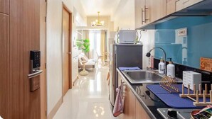 A modern kitchen with a built-in microwave, a sink, and a coffee station. - MOA Staycation 10mins to Airport. 10mins walk to iconic Mall of Asia. (Pasay)
