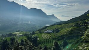 Terraced fields, a mountain, and a small building. - Dinh Sapa Trekking & Homestay (Ta Van)