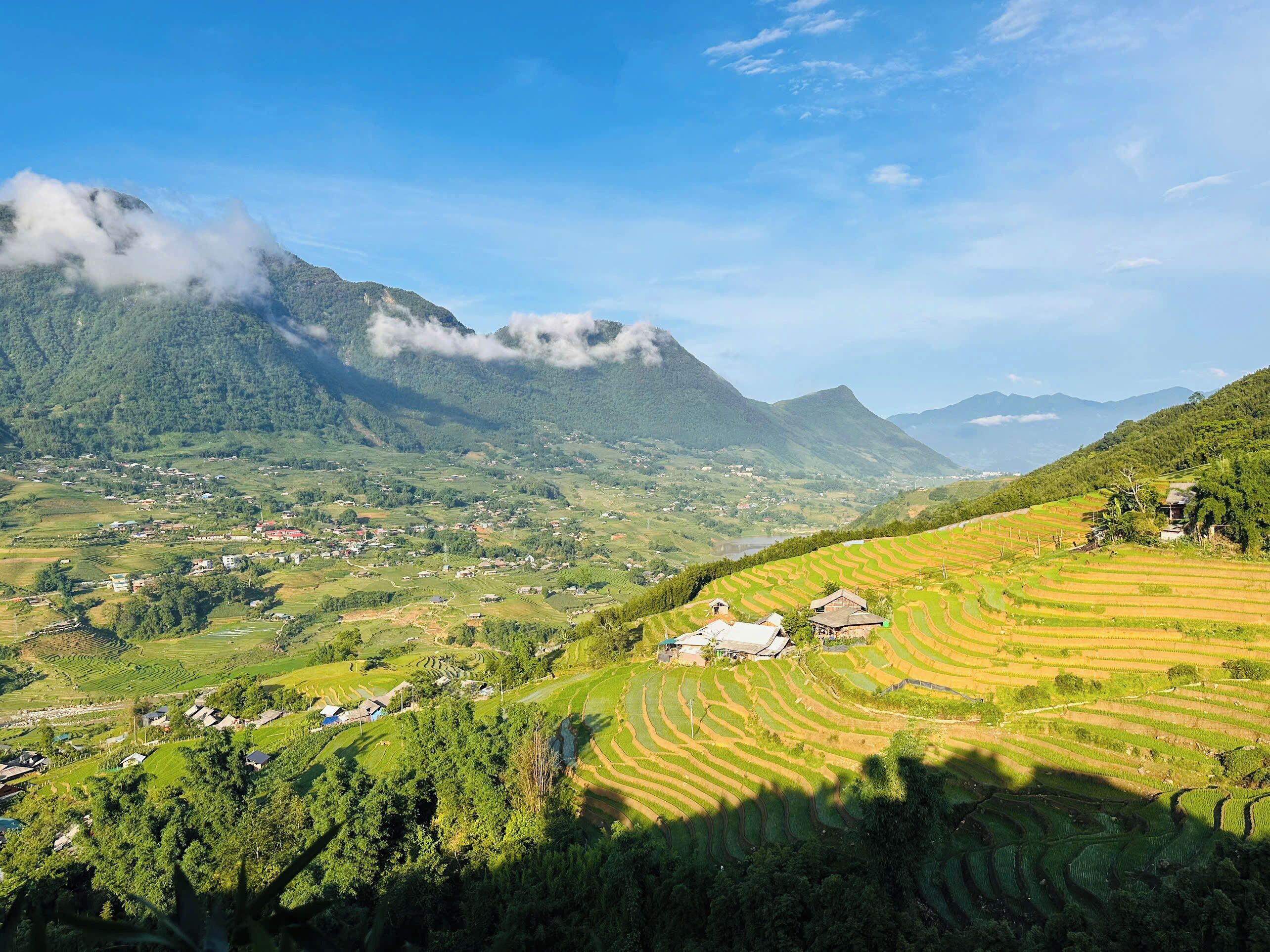 A mountainous landscape with terraced fields and scattered buildings.