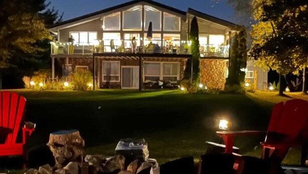 A modern house with a large deck, outdoor seating, and a fire pit. - Huron Lakefront Cottage Charming 8 bedrms 4bths 18+guests 8car/Hotub/pets . (Goderich)