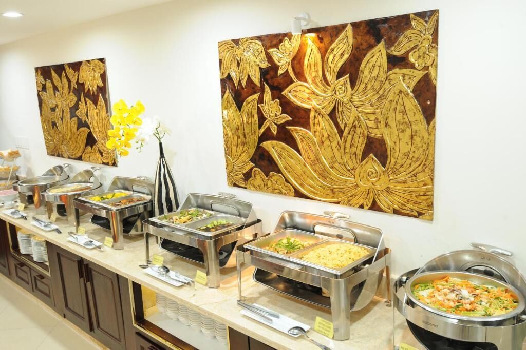 Disposição de buffet com diversas estações de comida e arte decorativa na parede.