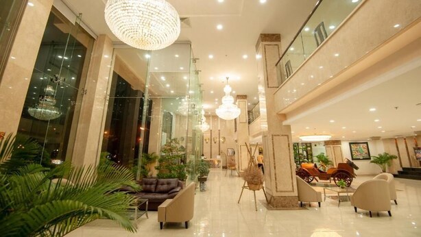 Un'ampia hall con un lampadario, zone relax e una reception.