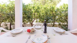 A table set for two with plates, cutlery, a bottle, and a glass. - 4085 Villa Teresa Portoselvaggio by Barbarhouse (Nardò)