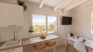 Una cocina con ventana, un lavamanos y una mesa con sillas.