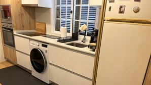A compact kitchen with a built-in washer, a sink, and a refrigerator.