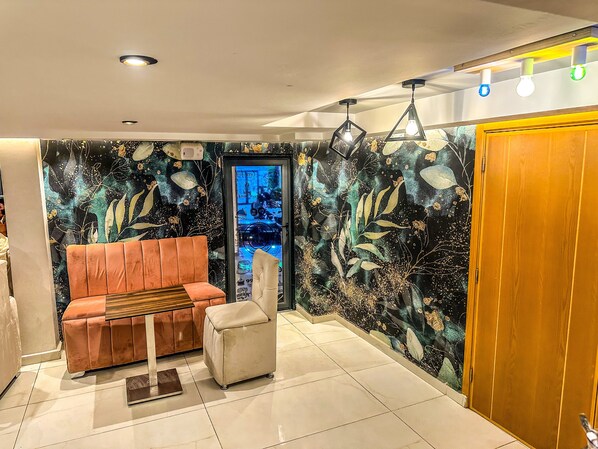 A modern living room with a sofa, a small table, and a decorative wall. - Hotel Beni Mellal Atlas (Beni Mellal)