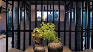 A modern meeting room with a long table, two potted plants, and a fruit platter. - Tetra Retreat (Kefalonia)