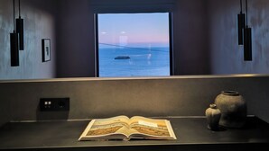 A modern room with a large window, a desk with a book, and a vase. - Tetra Retreat (Kefalonia)