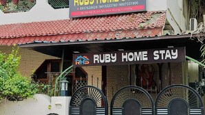 Edificio de dos pisos con un letrero que dice Ruby Home Stay.
