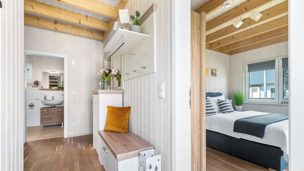 Ein modernes Schlafzimmer mit Bett, Nachttisch und Fenster.