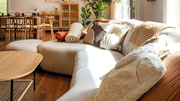 Una sala de estar acogedora con un sofá, una mesa de comedor y una zona de cocina.