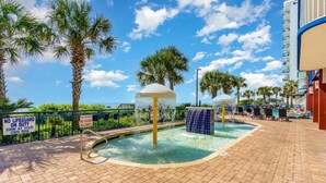 A pool area with palm trees, a no lifeguard sign, and a blue water feature. - Oceanfront 3bed 3bath condo! 19th floor. Amazing views indoor & outdoor pools (Myrtle Beach)