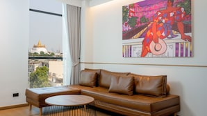 A modern living room with a leather sofa, a round coffee table, and a large painting. - Lub d Bangkok Chinatown (Bangkok)