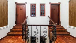 A staircase with wooden doors and windows, leading to an upper floor. - Olive Hotel Alidia Beach Resort by Embassy Group (Baga)