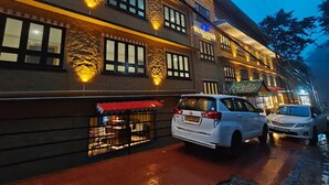 A multi-story building with a restaurant on the ground floor, featuring a red awning and a visible entrance. - The Mansarovar Hotel & Banquet (Gangtok)