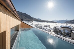 A modern building with a glass pool overlooking a snowy landscape and mountains. - Auramonte (Curon Venosta)