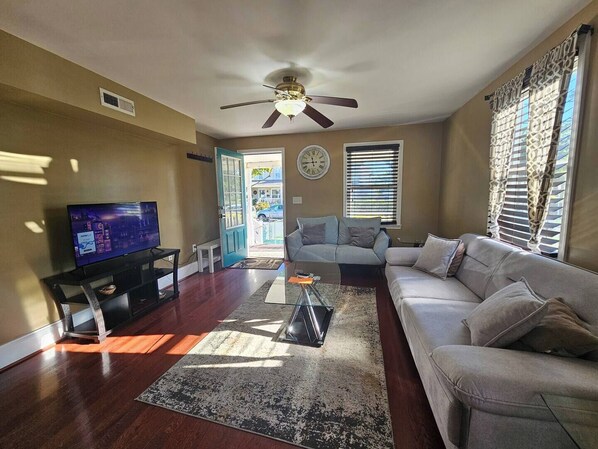 A living room with a television, two sofas, a coffee table, and a ceiling fan. - This duplex is a 3 bedroom(s), 2 bathrooms, located in Towson, MD. (Towson)