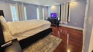 A modern bedroom with a bed, a TV, and a dresser.