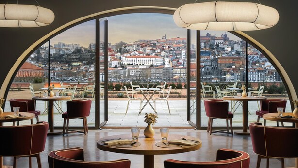 A restaurant with round tables and red chairs, large windows offering a city view. - Tivoli Kopke Porto Gaia Hotel (Vila Nova de Gaia)