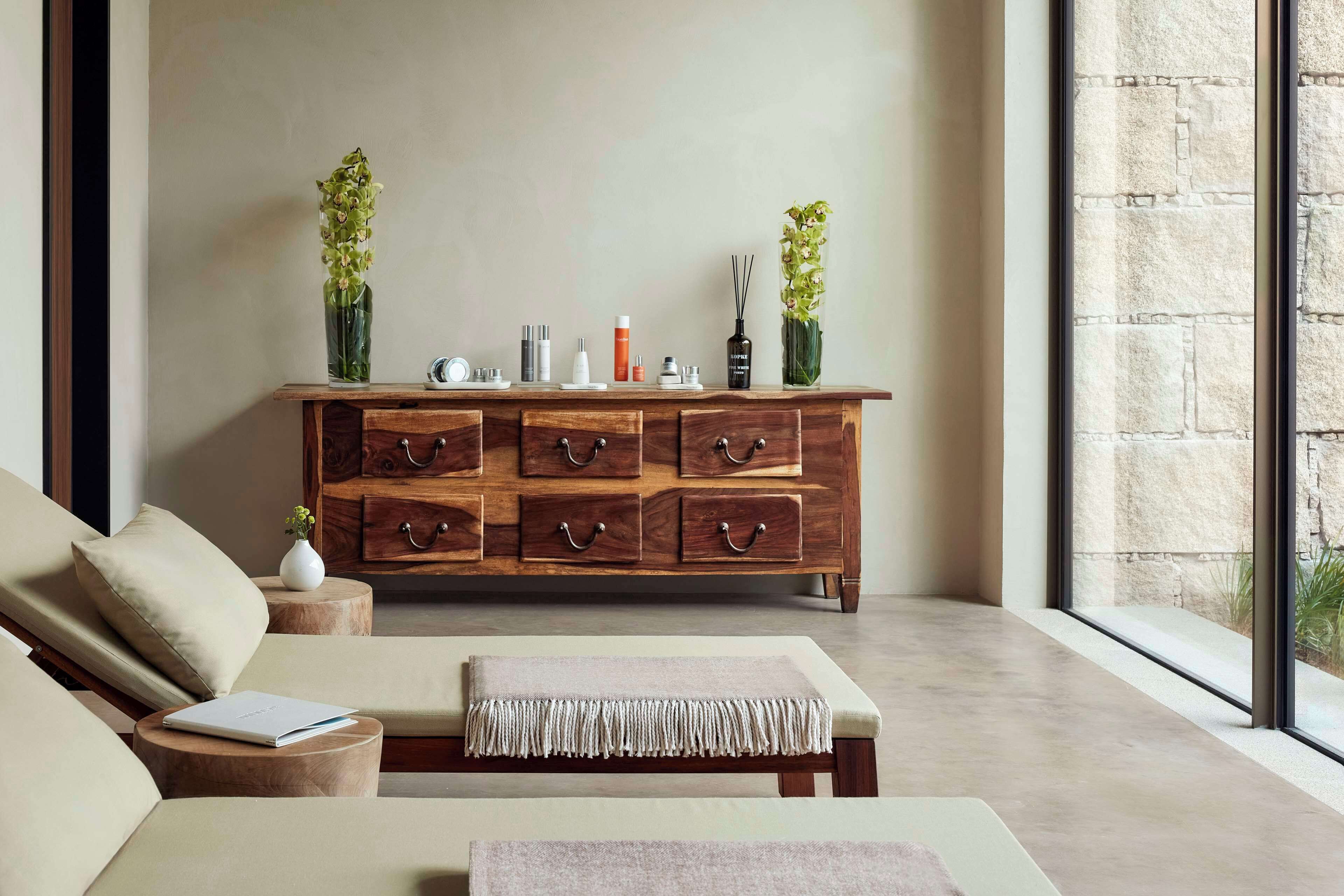 A modern living room with a wooden cabinet, a sofa, and a bench.