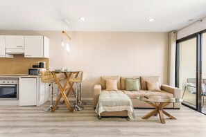 A modern living space with a kitchen, dining area, and seating area.