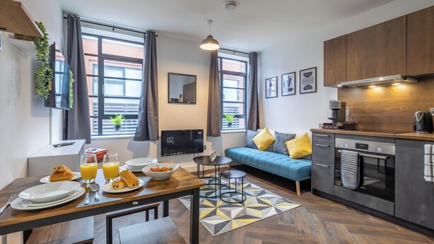 A modern apartment with a dining area, kitchen, and living space.