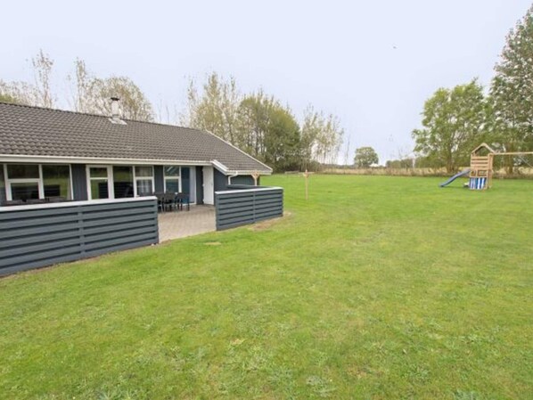 A building with a flat roof and a fenced yard.