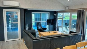 Ein modernes Zimmer mit einer Couch, einem Holztisch und einem Fernseher.