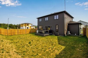 A two-story house with a front deck, a fenced backyard, and a neighboring house. - NEW Golfers Dream Modern Patio King Bed (St. John's)