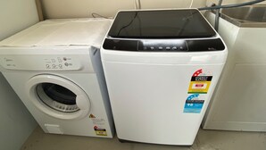 A front-loading washing machine and a dryer side by side in a laundry room. - Close to Trade Central Mall, 3 Bedrooms, Sleeps 6, Wheelchair friendly (Rotorua)