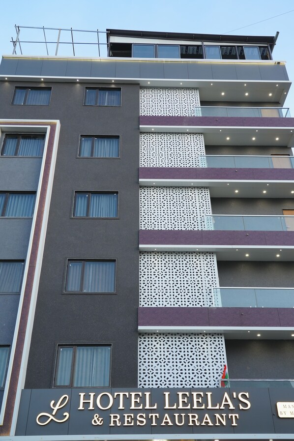 A multi-story building with a sign for Hotel Leela's & Restaurant. - Hotel Leela's (Dwarka)