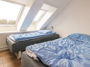 A bedroom with two beds, a skylight, and a view of the sky. - 4 Star Holiday Home in Vestervig (Vestervig)