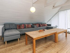A modern living room with a grey sofa, a wooden coffee table, and a hanging light fixture. - 4 Star Holiday Home in Vestervig (Vestervig)