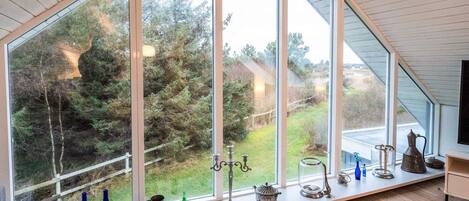 A room with a large window, a sofa, and various decorative items on the windowsill.