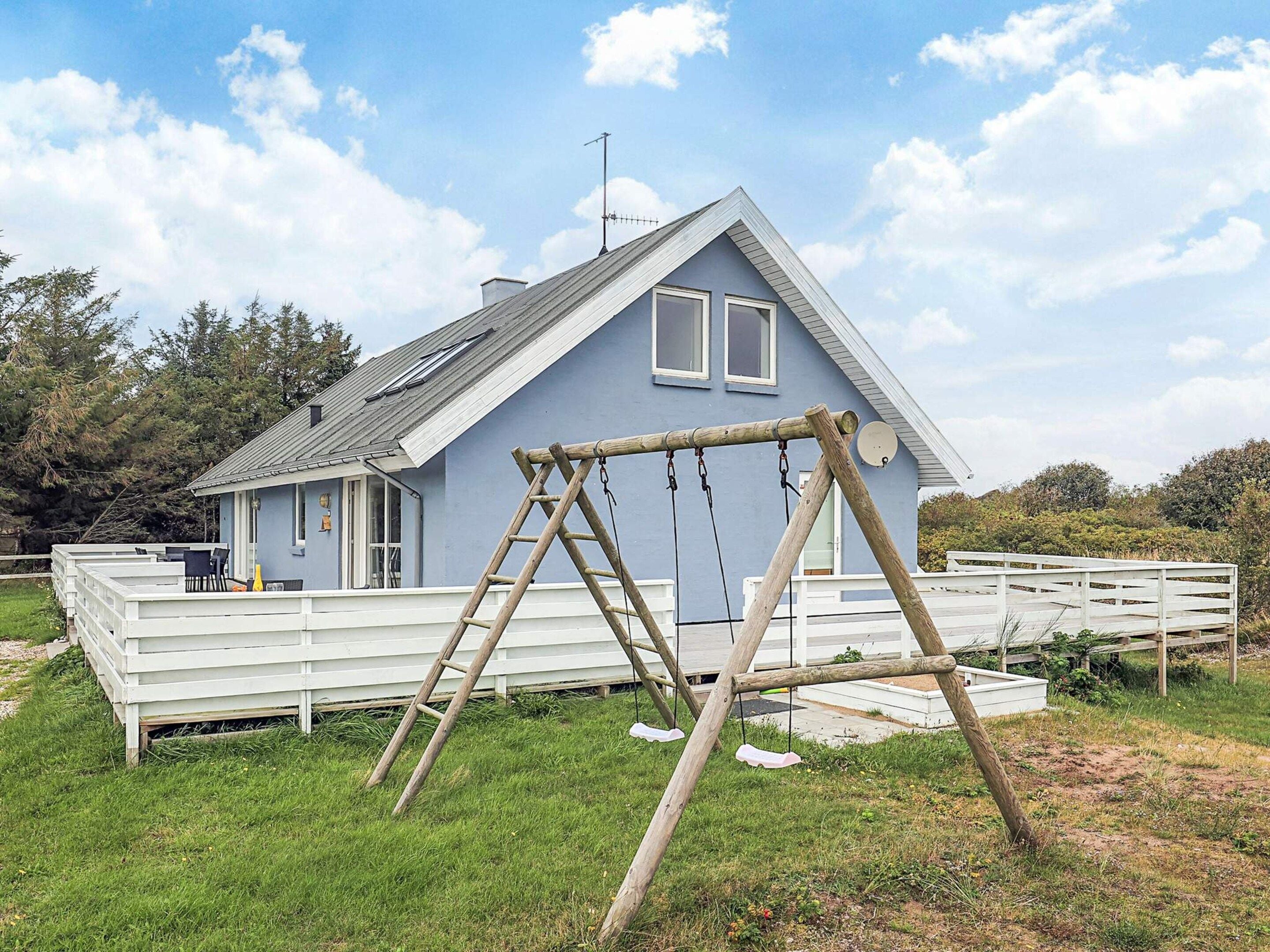 A house with a porch and a swing set.