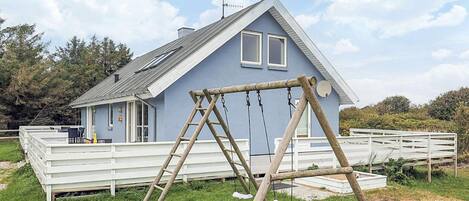 A house with a porch and a swing set.