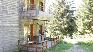 A wooden cabin with a deck and a small outdoor seating area. - Apartment near slopes with terrace (Chamrousse)