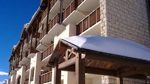 Un hotel de varios pisos con balcones y fachada de piedra.