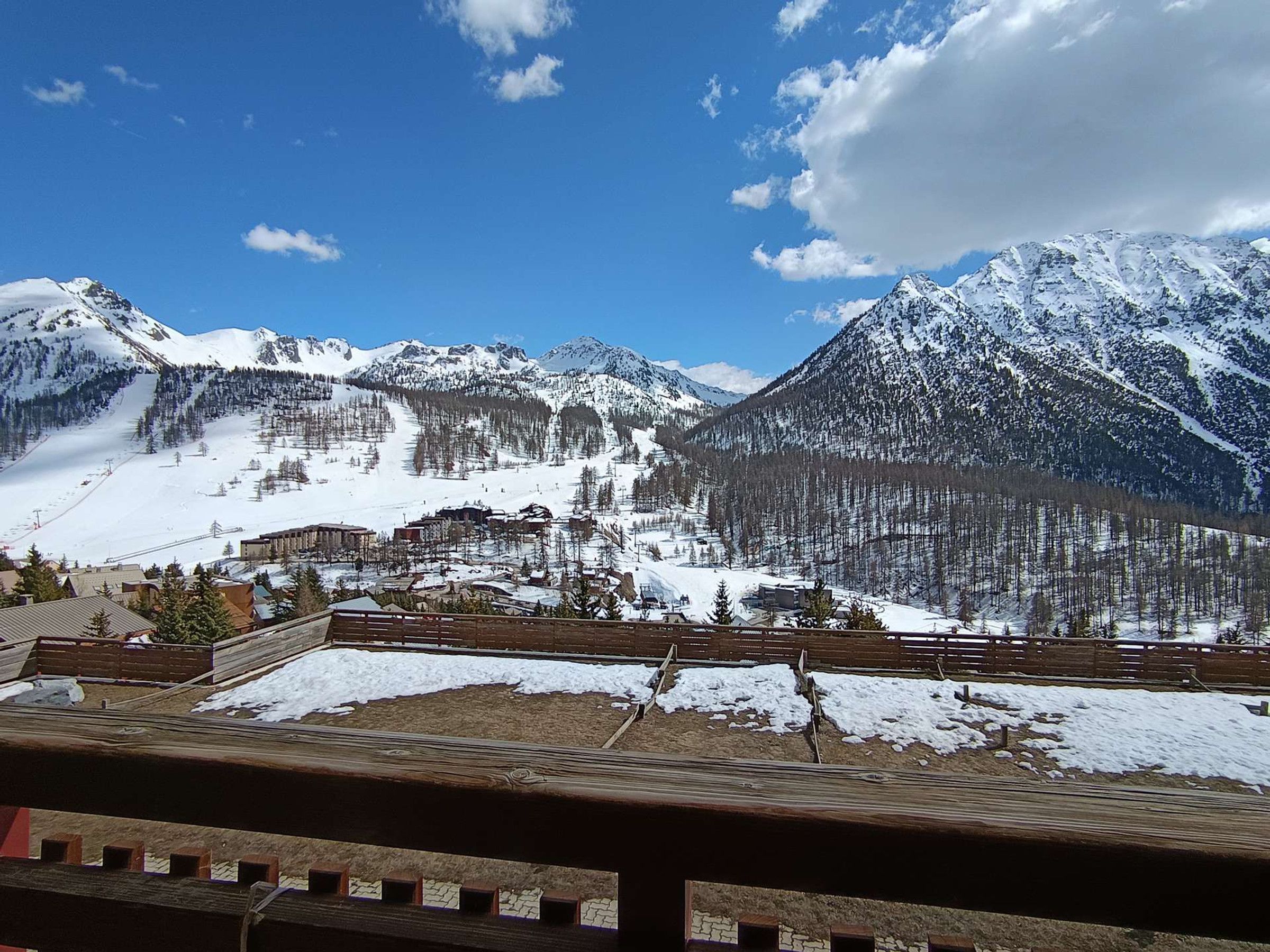 A mountainous landscape with snow-covered peaks and a ski resort in the valley.