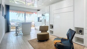 Una sala de estar moderna con comedor, un ventanal y vistas al exterior.