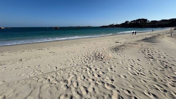 A sandy beach with footprints, calm water, and a clear sky. - Contemporary villa 100m from the beach with garden and WIFI (Trégastel)