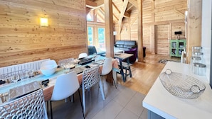 A wooden cabin interior with a dining area, a sofa, and a kitchen. - Luxury Chalet with Spa & Sauna in Vars (Vars)